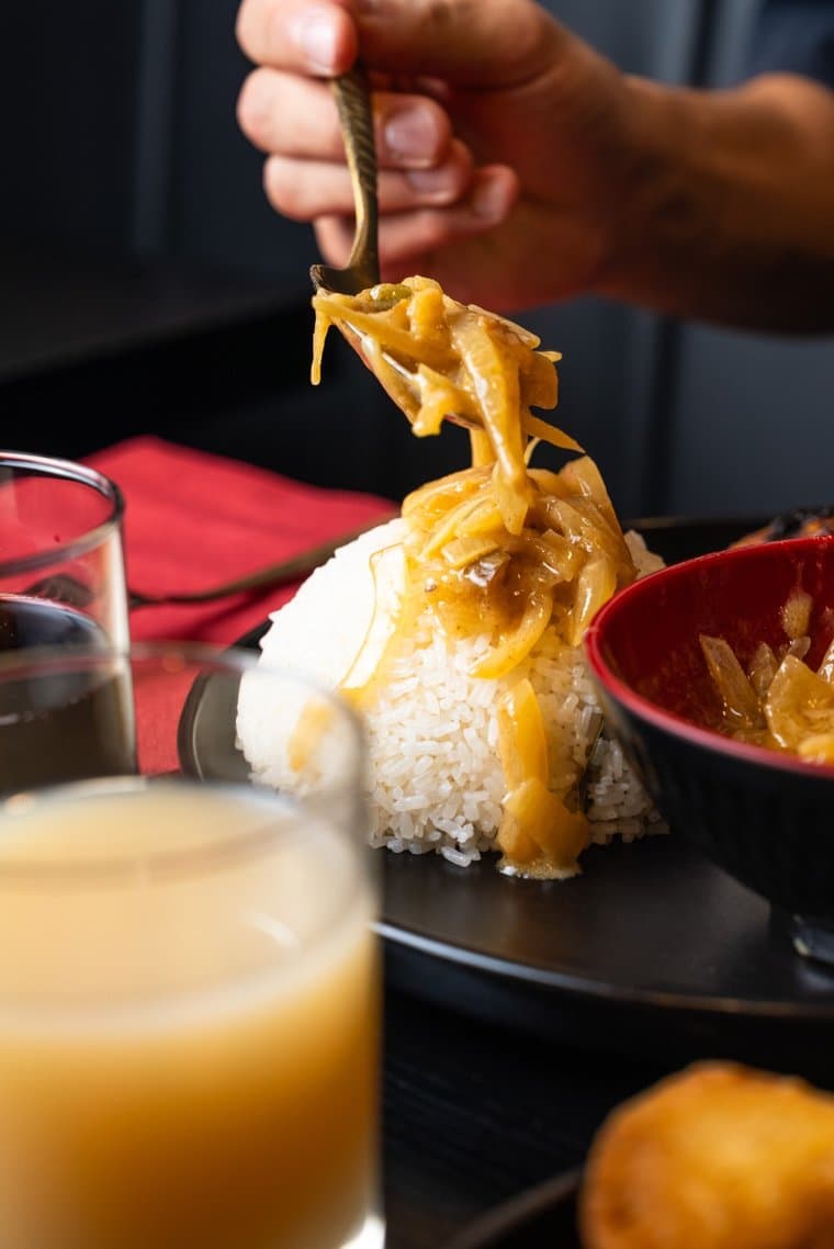 La sauce mafé versée à la cuillère sur le riz blanc